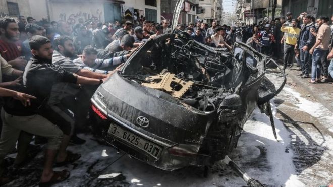 Палестинский спасатель пытается потушить огонь на автомобиле