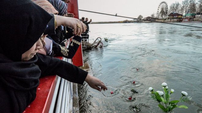 Иракские женщины бросают цветы в реку Тигр в Мосуле в память о погибших в результате аварии на пароме (22 марта 2019 года)