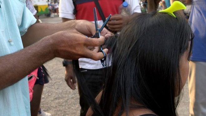Luis Fernando cuts a woman's hair