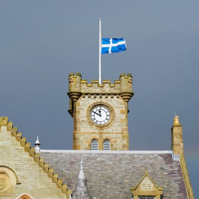 Шетландский флаг развевается над мачтой над ратушей Леруика.