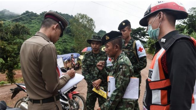 A Thai policeman speaks with a Thai soldier at the Tham Luang cave area on 8 July 2018.