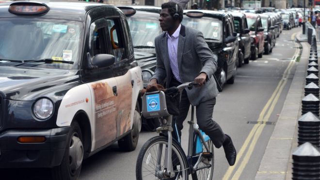Человек на велосипеде рядом с линией такси