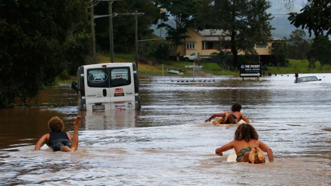 Жители Биллиудгеля, Новый Южный Уэльс, использовали доски для серфинга, чтобы грести по улице.
