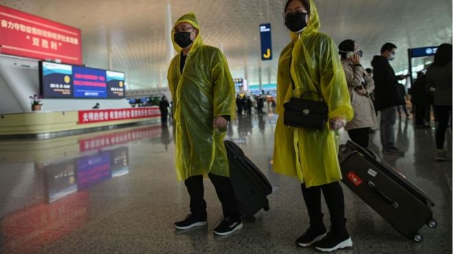 Пассажиры в защитном снаряжении ходят по открытому сегодня аэропорту Тяньхэ в Ухане, центральная китайская провинция Хубэй, 8 апреля 2020 года.
