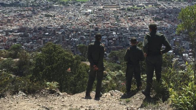 Policías miran la ciudad desde el cerro.