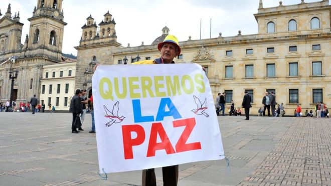 Man holds a sign reading "We want peace" outside the Colombian Senate in Bogota, on November 29, 2016