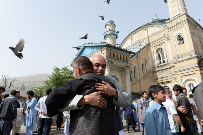 Афганские мусульмане обнимают друг друга после молитвы в начале праздника Ид аль-Фитр, который отмечает окончание Рамадана в мечети Шах-до-Шамшира в Кабуле 15 июня 2018 года