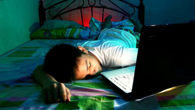 Ребенок с компьютером в постели