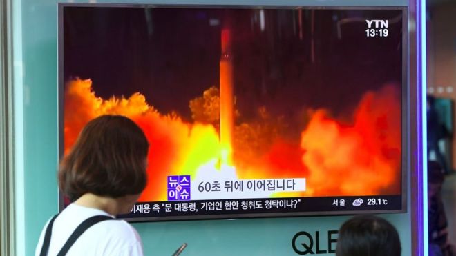 Люди смотрят телевизионный экран, демонстрирующий видеозапись последнего испытательного запуска межконтинентальной баллистической ракеты (МБР) в Северной Корее на железнодорожной станции в Сеуле