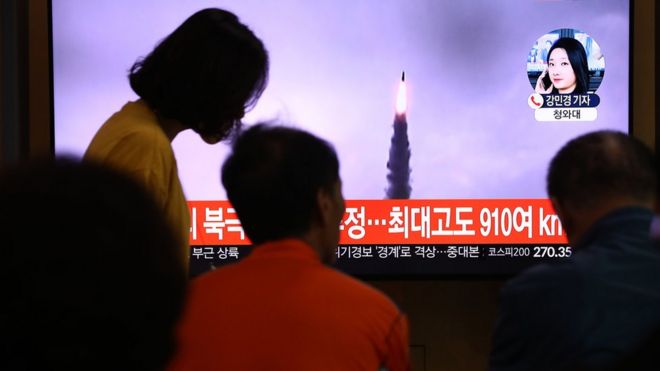 Люди смотрят телевизор, показывающий файл с изображением пуска северокорейской ракеты на железнодорожном вокзале Сеула 2 октября 2019 года в Сеуле,