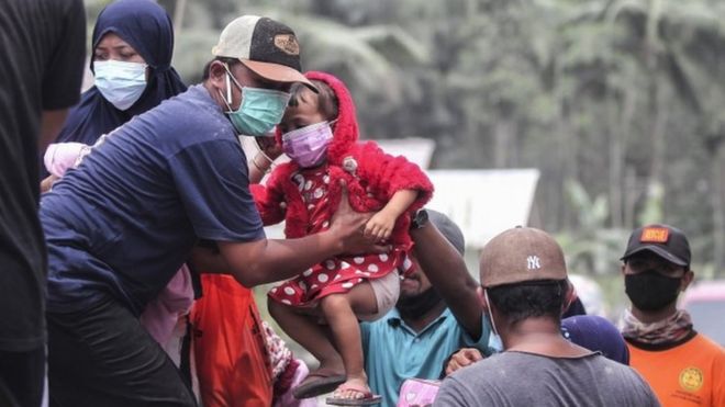 Officials evacuate people from Kamar Kajang village in East Java to safer places after the eruption of Mt Semeru