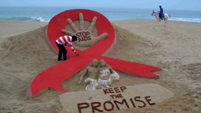 Скульптура индийской художницы по песку Судерсана Паттнаика накануне Всемирного дня борьбы со СПИДом на пляже Золотого моря в Пури, штат Орисса, 29 ноября 2013 года