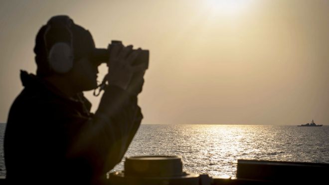 Soldado a bordo del buque destructor estadounidense USS Stethem mirando a la distancia con binoculares