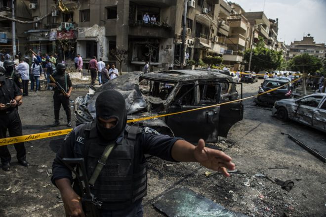 Египетские силы безопасности стоят на страже у места взрыва бомбы, нацеленного на конвой государственного обвинителя Египта Хишама Бараката, который скончался через несколько часов после мощного взрыва в его колонне, в столице Каире 29 июня 2015 года.