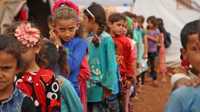 Перемещенные сирийские дети стоят в очереди во временной школе в лагере в Атме, провинция Идлиб (1 октября 2018 года)