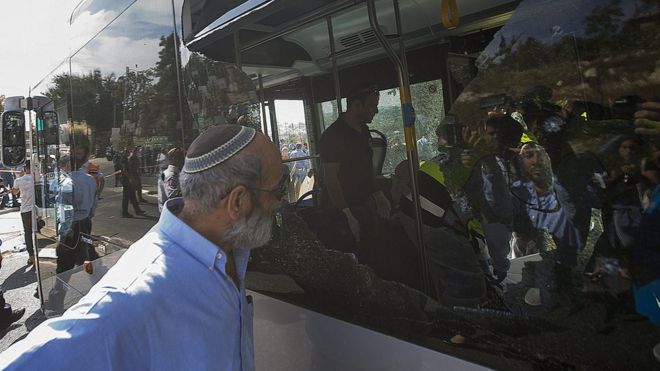 Израильтянин заглядывает в автобус на месте, где два человека открыли огонь в районе Армон Ханатзив недалеко от арабского района Джабаль Мукабер в Иерусалиме