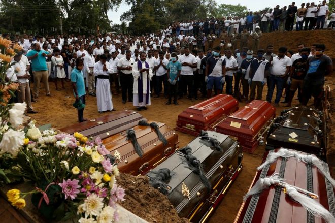 Люди участвуют в массовых похоронах семи жертв, принадлежащих к одной семье, в Негомбо, Шри-Ланка, 24 апреля