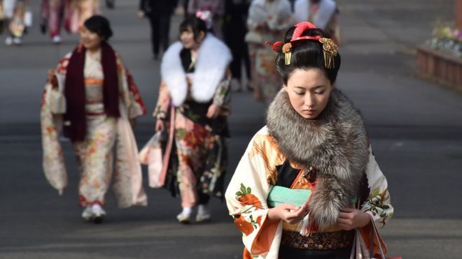 Двадцатилетние женщины в кимоно уходят после участия в праздновании «Дня совершеннолетия»
