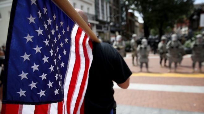 Un manifestante con la bandera de EE.UU. en Charlottesville.