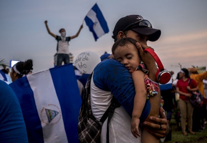 Отец держит своего сына во время одной из многочисленных демонстраций, призывающих к отставке президента Ортеги в апреле 2018 года.