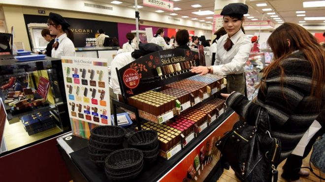 Mulher japonesa comprando chocolate em uma loja de departamento