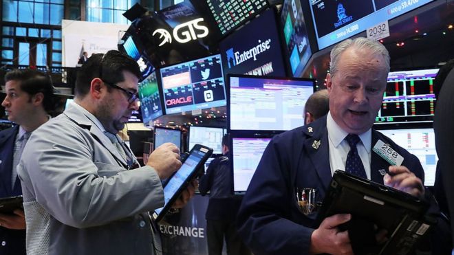 Трейдеры и профессионалы в области финансов работают на площадке Нью-Йоркской фондовой биржи (NYSE), 20 декабря 2016 г.