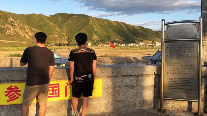 Люди смотрят в Северную Корею из Тюмени, Китай. 30 августа 2017