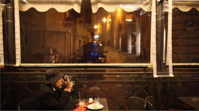 Homem em cafeteria, observando, sem fazer nada - il dolce far niente italiano