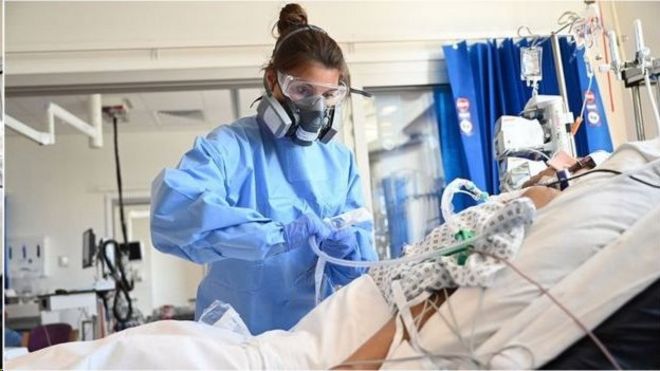 Médica de equipamento de proteção trata de paciente em hospital