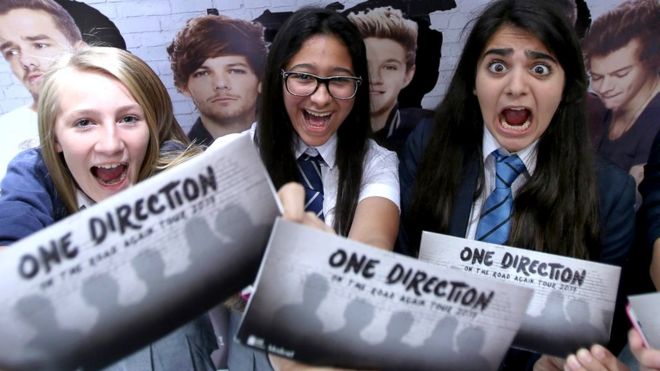 Поклонники держат билеты на тур One Direction