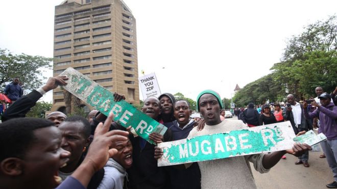 Протестующие держат плакаты во время марша против президента Зимбабве Роберта Мугабе на территории Зимбабве в Хайфилде, Хараре.