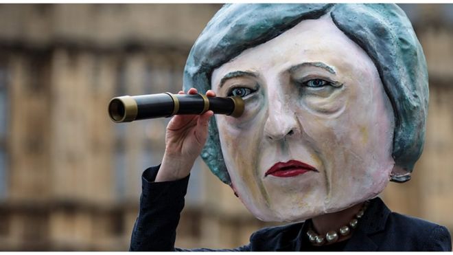 Девушка в маске Терезы Мэй в ожидании решения парламента