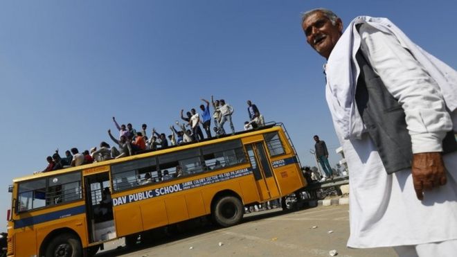 Демонстранты из общины Джат сидят на вершине школьного автобуса, блокируя национальное шоссе Дели-Харьяна во время акции протеста в деревне Сампла в Харьяне, Индия, 22 февраля 2016 года.