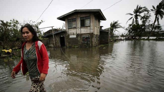 Филиппинский сельский житель пробирается сквозь паводковую воду в городе Баггао, пострадавшем от тайфуна