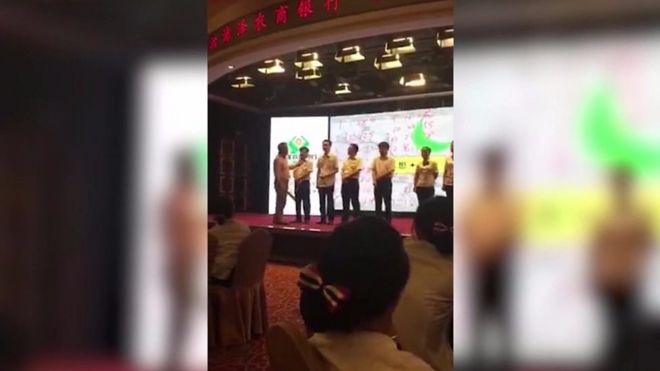 Entrenador golpeando a un grupo de empleados de un banco chino