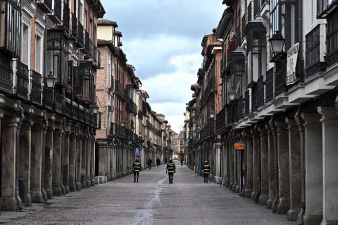 Policiais espanhóis caminham por uma rua vazia em Alcala de Henares, na Espanha.
