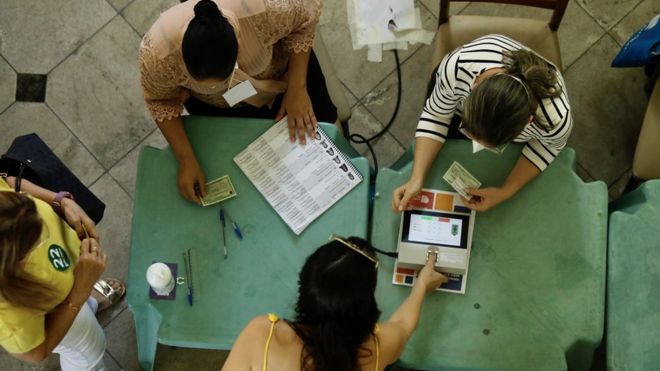 mulher faz leitura da biometria antes de votar