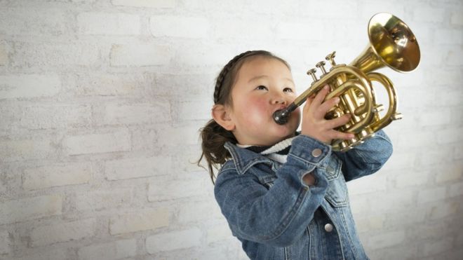 Una niña tocando la trompeta