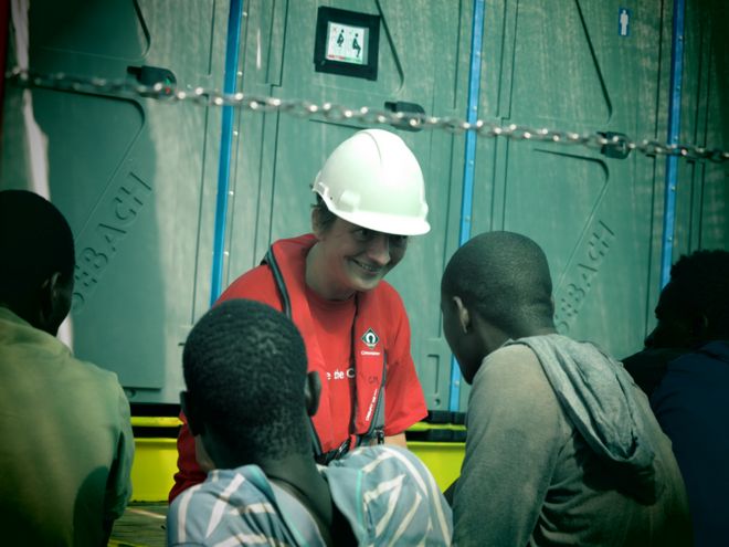 Волонтер на борту беседует с мигрантами