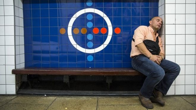 Пассажир отдыхает на скамейке у станции метро Oxford Circus