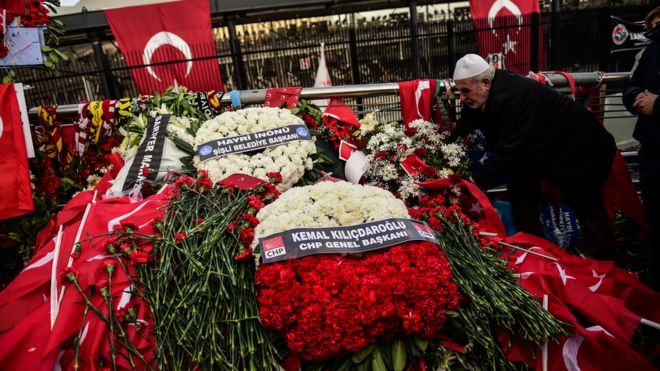Мужчина возлагает цветы на месте взрыва двойной бомбы возле футбольного стадиона Vodafone Arena в Стамбуле, 14 декабря 2016 года