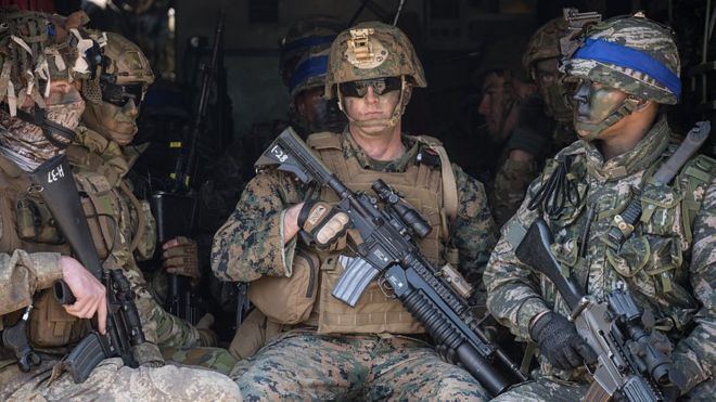 Солдаты Южной Кореи и США сидят в автомобиле-амфибии, позируя фотографам во время ежегодных совместных военных десантных учений