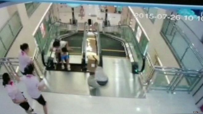 Видеонаблюдение, демонстрирующее женщину и ребенка на эскалаторе, предоставленное системой видеонаблюдения Reuters, 26 июля 2015 г. Сотрудникам удалось вытащить ребенка в безопасное место после того, как мать оттолкнула его от пропасти