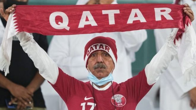 Fan holding a Qatar football scarf