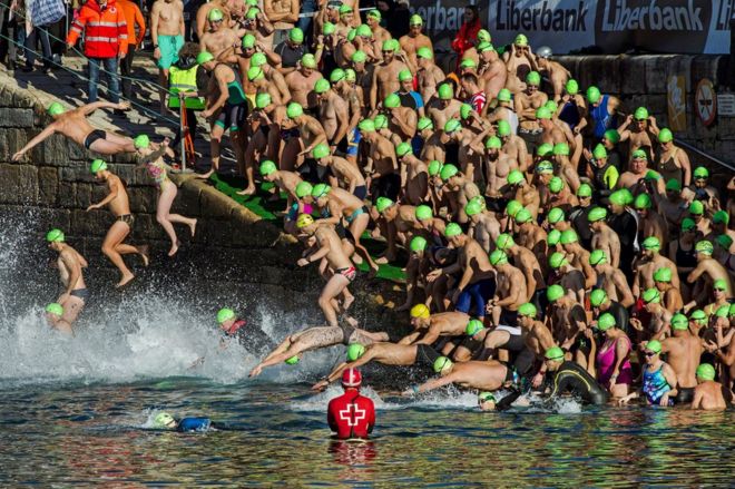 Swimmers jump into the water at the start of the Christmas Crossing 2017 in Gijon, Spain, 25 December 2017