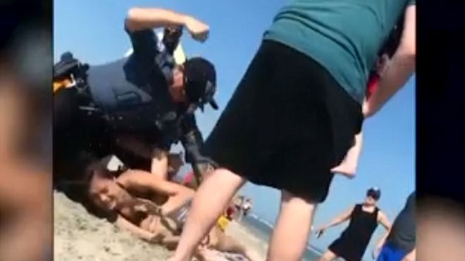 Police officer filmed hitting a woman