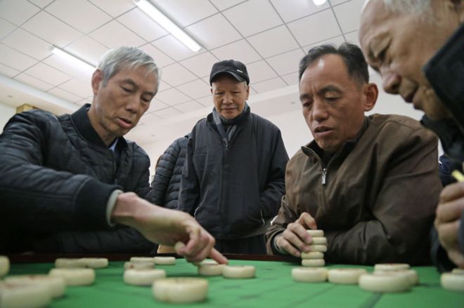 Играя в настольную игру в центре Фуцзянь для пожилых людей