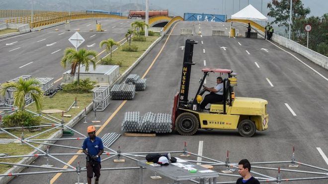 Workers assemble the platform for the February 22 concert organized by British billionaire Richard Branson to raise money for the Venezuelan relief effort in Cucuta, Colombia, on the Tienditas International Bridge (which has been blocked with containers by loyalists of Venezuelan President Maduro to prevent access to the country)