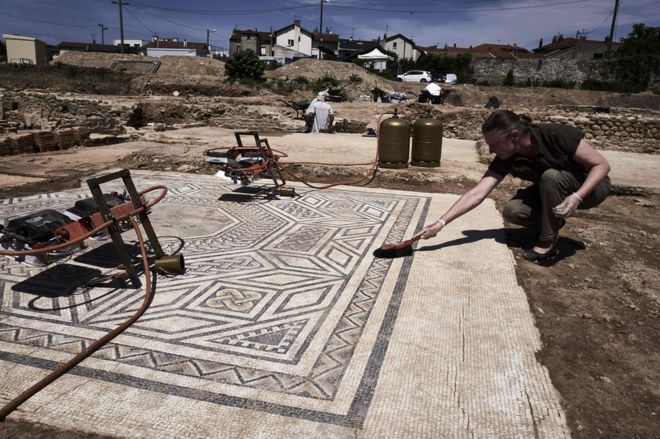 An archaeologist works on a mosaic near Vienne, south-eastern France, 31 July