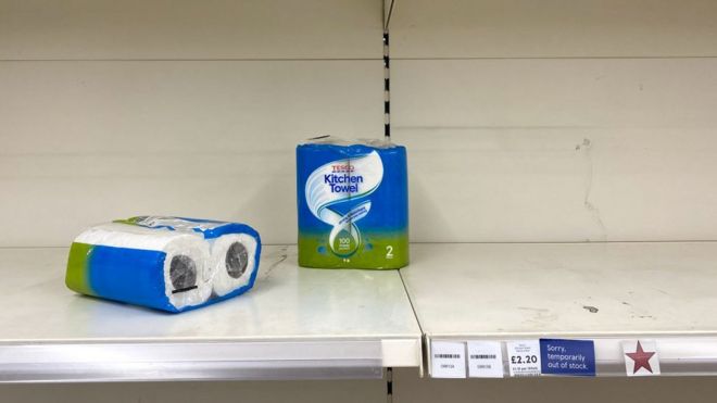 Two packets of kitchen towel on an empty supermarket shelf